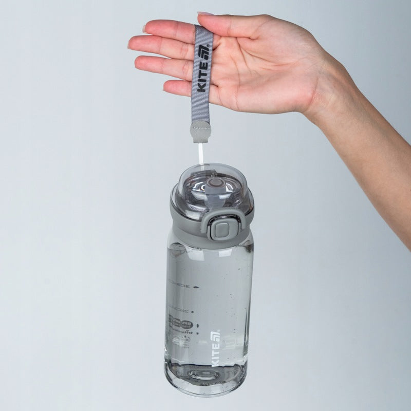Ręka trzymająca szarą butelkę tritanową Kite 500 ml za pasek tekstylny